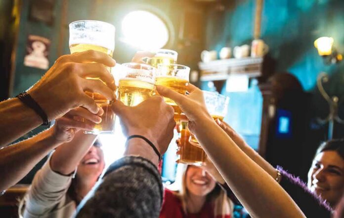 shutterstock_1085215253 group toasting with beer glasses in a pub