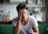 Migraines: Why Some Patients Suffer Far More Than Others Man with headache holding a glass of water