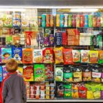 Child looking at a shop window filled with snacks and cereals