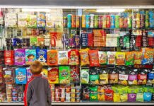 Consumer Reports Drops Snack Bombshell Child looking at a shop window filled with snacks and cereals