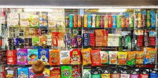 Child looking at a shop window filled with snacks and cereals