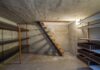 Why Your Knees Hurt Walking Down The Stairs Concrete basement with shelves and a metal staircase
