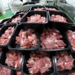 Trays of raw meat in a processing facility