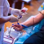 Nurse draws blood from a donor's arm
