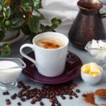 Coffee-Only Mornings? Hidden Hormone Chaos Cup of coffee with milk, butter, and spices on a table