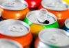 Assorted soda cans with one open pull-tab