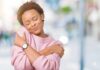 The Japanese secret to being happier and calmer Woman in pink sweater hugging herself with eyes closed