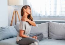 Stronger Bones? Wrong Battle, Say Docs Woman sitting on couch holding her neck