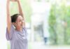 3 Tips To Slow Down Your Skin’s Biological Clock woman stretching with arms raised indoors near window
