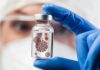 Deadly Lab Leak Incident Triggers U.S. Alarm Gloved hand holding a small vial in a lab