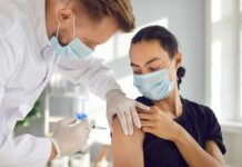 America’s Health Care Workforce Crisis Healthcare worker giving a masked patient a vaccine in the upper arm