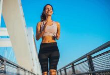 Treadmill Trick That Mimics Brutal Summits Smiling woman jogging on a bridge under a clear blue sky