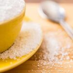 Yellow bowl and plate with spilled granulated sugar