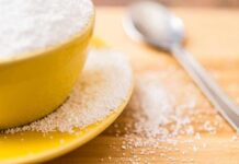 Yellow bowl and plate with spilled granulated sugar