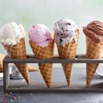 Four ice cream cones in a wooden stand